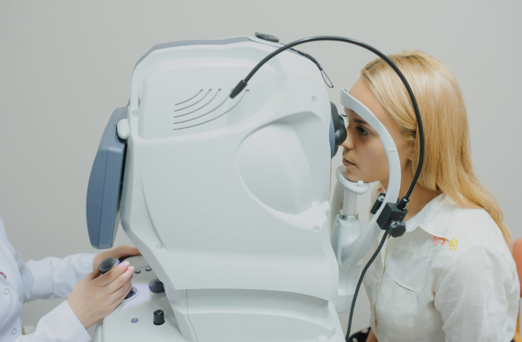 A younger woman receiving an OCT eye scan during her comprehensive eye exam