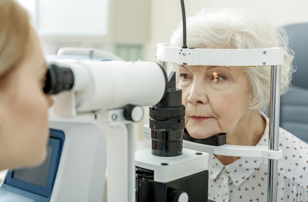 An older woman having her eyes examined by an optometrist