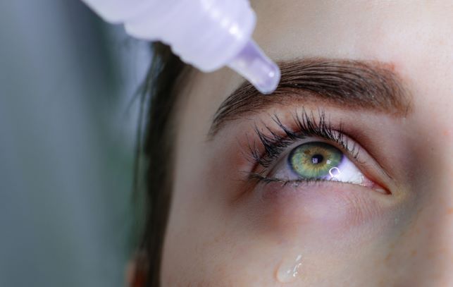 Close up of women putting in eye drops to relive dry eye