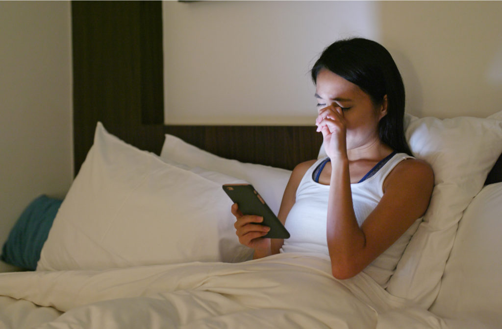 Women experiencing dry eye due to screen time before sleeping in bed