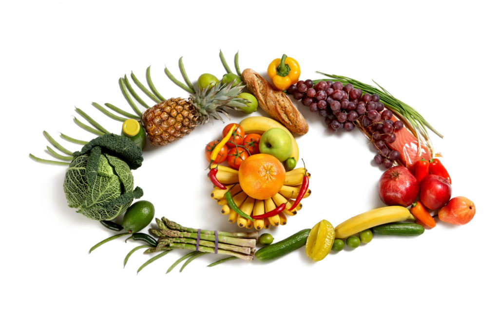 A variety of fruits and vegetables are shaped into an eye. Good sources of vitamins that are beneficial for the eyes