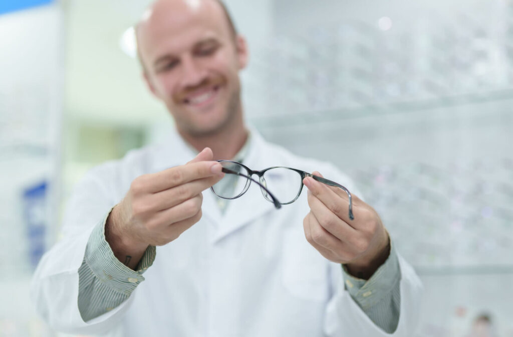 A male ophthalmologist inspecting a newly prescribed eyeglasses for his patient.